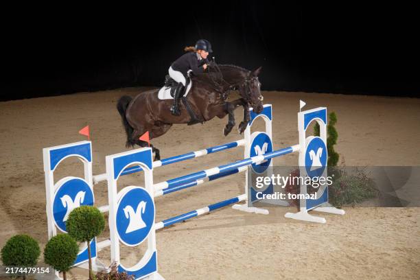 junges mädchen mit pferd über die hürde springen - reitsport-veranstaltung stock-fotos und bilder