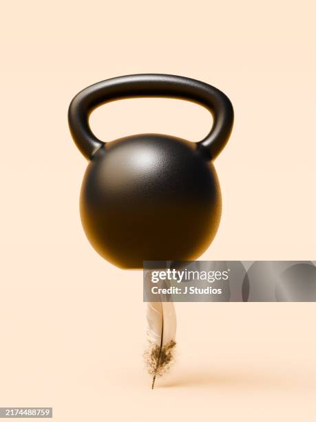 weight on of feather defying gravity - ruffled feathers stock pictures, royalty-free photos & images