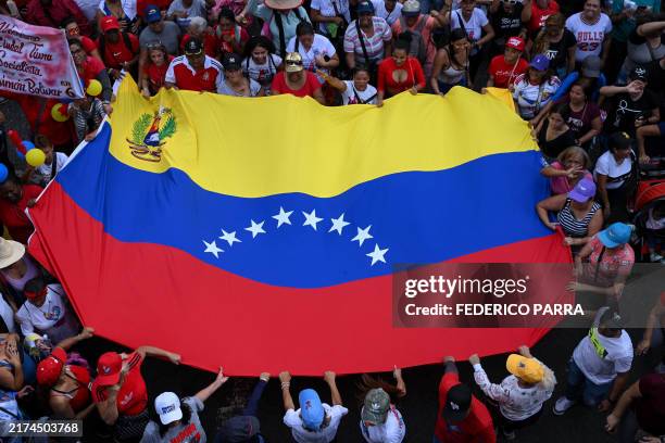 Supporters of Venezuelan President Nicolas Maduro wave a Venezuelan flag during a rally called by the ruling party two months after the disputed...
