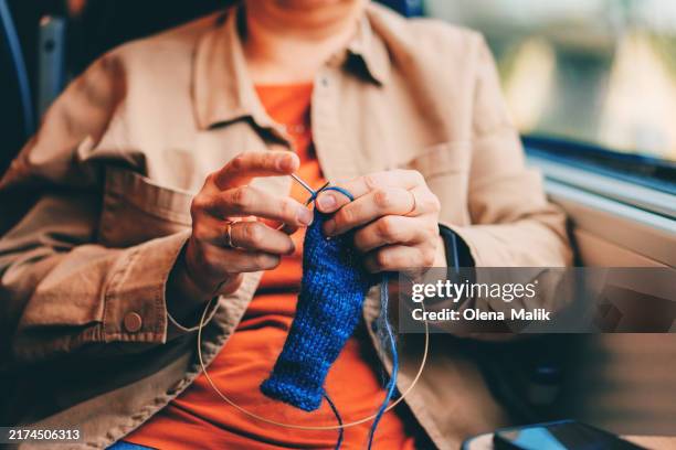 woman knitting while traveling on a train - knitting stock pictures, royalty-free photos & images