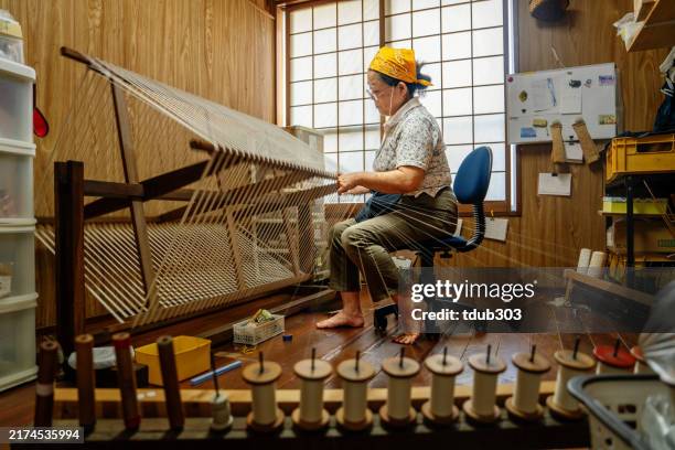 mujer mayor preparando un carrete para tejer - prefectura de okinawa fotografías e imágenes de stock