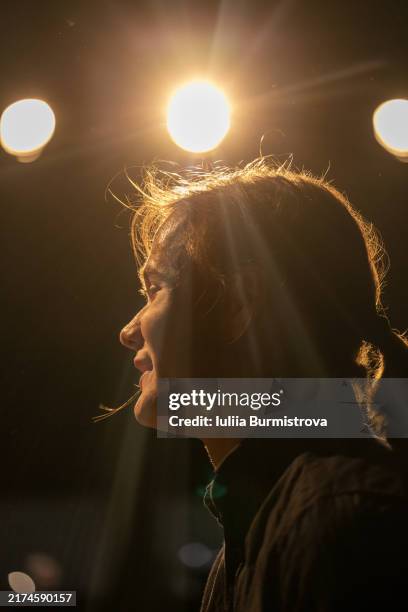 talented young male performer backlit by stage lights reading captivating dialog on stage of student drama club - musical theater stock pictures, royalty-free photos & images