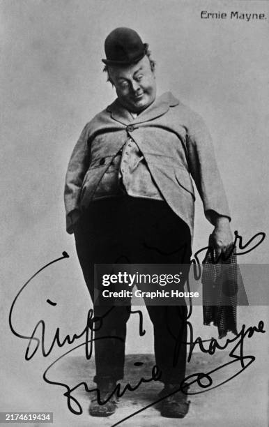 Signed postcard featuring English comic Ernie Mayne wearing a small bowler hat and a very tight jacket over his large torso, circa 1910.