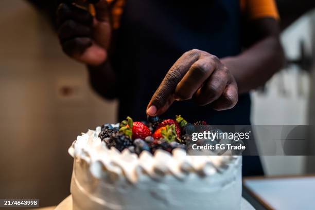 close-up of a man decorating a cake - decorating a cake stock pictures, royalty-free photos & images