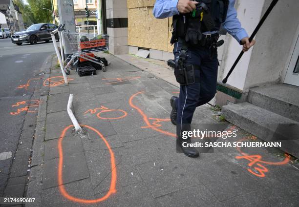 Police officer patrols in front of a food shop where a man rammed a van into it in Essen, western Germany, on September 29 the day before. A...