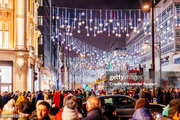 oxford street decorated with bright christmas lights in winter at night, london, england, uk - oxford street london stock pictures, royalty-free photos & images