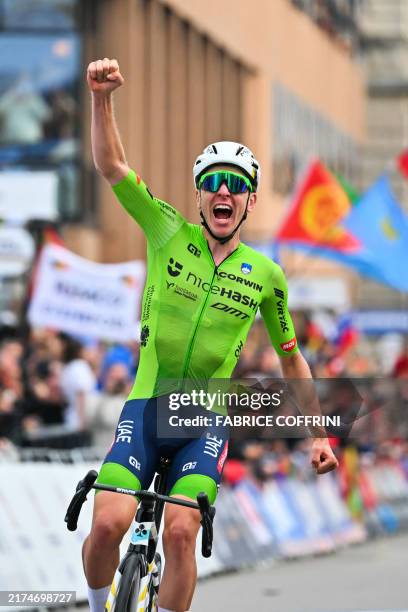 Slovenia's Tadej Pogacar celebrates as he crosses the finish line to win the men's Elite Road Race cycling event during the UCI 2024 Road World...