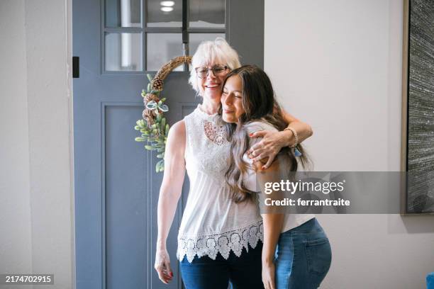 die großmutter kommt nach hause, um die familie zu besuchen, und umarmt die enkelin - trennungsschmerz stock-fotos und bilder