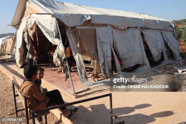 Syrian children attend class at a makeshift school, set-up in camp for internally displaced Syrians, in the village of Haranabush, in the country's...