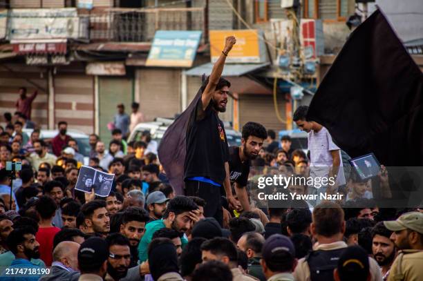Kashmiri Shiite Muslims holding pictures of Hassan Nasrallah as they try to march, chanting anti-Israel and anti-U.S. Slogans, in protest of...