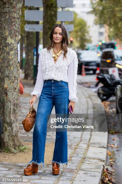 Ellinor Malecaze wears white blouse, golden necklace, denim jeans, brown bag, clogs outside Chloe during Womenswear Spring/Summer 2025 as part of...