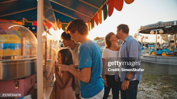 du temps en famille au stand de barbe à papa du parc d’attractions - parc dattractions photos et images de collection