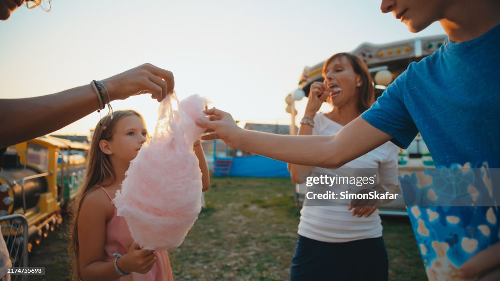 Family Enjoying Sweet Treats at Amusement Park
