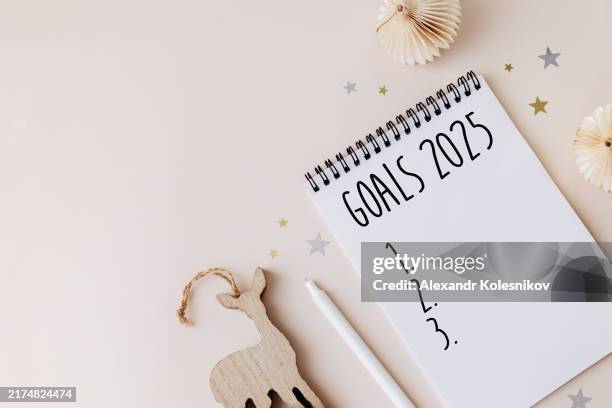 2025 goals list concept. notebook, pen and decoration on beige table. goals, resolutions, plan, action, checklist concept. new year 2025. flat lay, copy space - neujahrsvorsatz stock-fotos und bilder