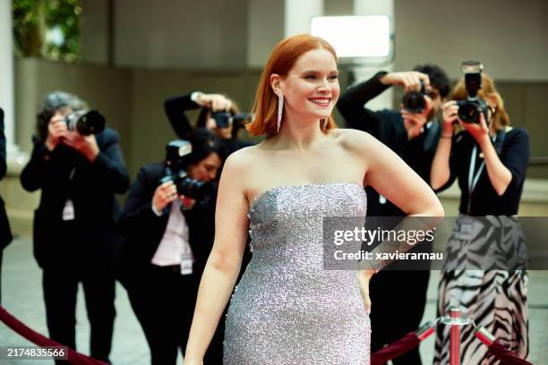 elegant celebrity in silver gown posing on red carpet - celebrities stock pictures, royalty-free photos & images
