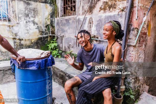 young couple talking to friends on slum outdoors - cuban people stock pictures, royalty-free photos & images