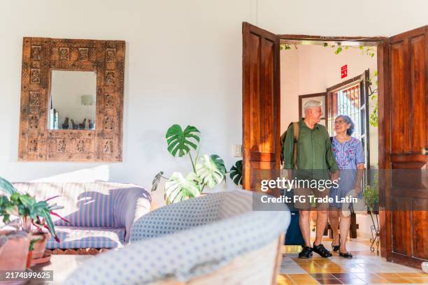 älteres paar spricht und kommt mit koffer im hotel auf dem zimmer an - hotelzimmer tür stock-fotos und bilder