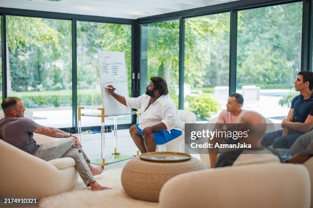 black therapist conducts group session in rehab facility - trigger stock pictures, royalty-free photos & images