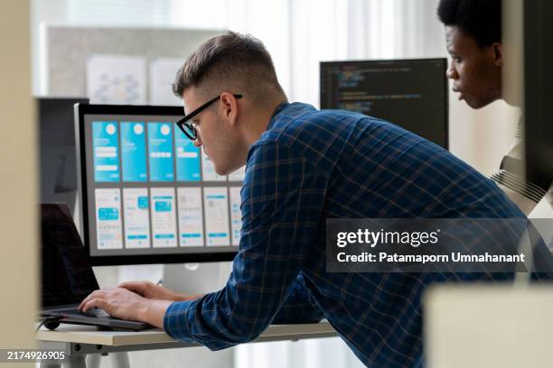 both of it professionals working together in an office setting, solving digital problems related to cybersecurity, software development, and coding. the team is engaged in programming and troubleshooting html code, focusing on data science, security. - scriptwriter stock pictures, royalty-free photos & images