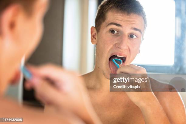 mann mit einem zungenschaber - menschliche zunge stock-fotos und bilder
