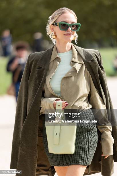 Leonie Hanne wears gold earrings, green feather heeled sandals, green sunglasses, a light green suede shirt, a mint green t-shirt, a dark green mini...