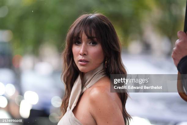 Guest wears halter beige top with gold detail, outside Rabanne, during the Paris Fashion Week Spring/Summer 2025 on September 25, 2024 in Paris,...