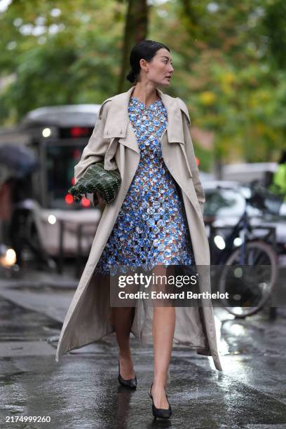 Guest wears beige trench coat, blue chain Rabanne over the knee dress, dark green chain Rabanne bag, black slingback leather heels, outside Rabanne,...