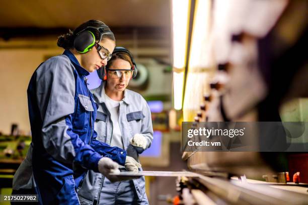 skilled female workers operating press brake in industrial setting - manufacturing stock pictures, royalty-free photos & images