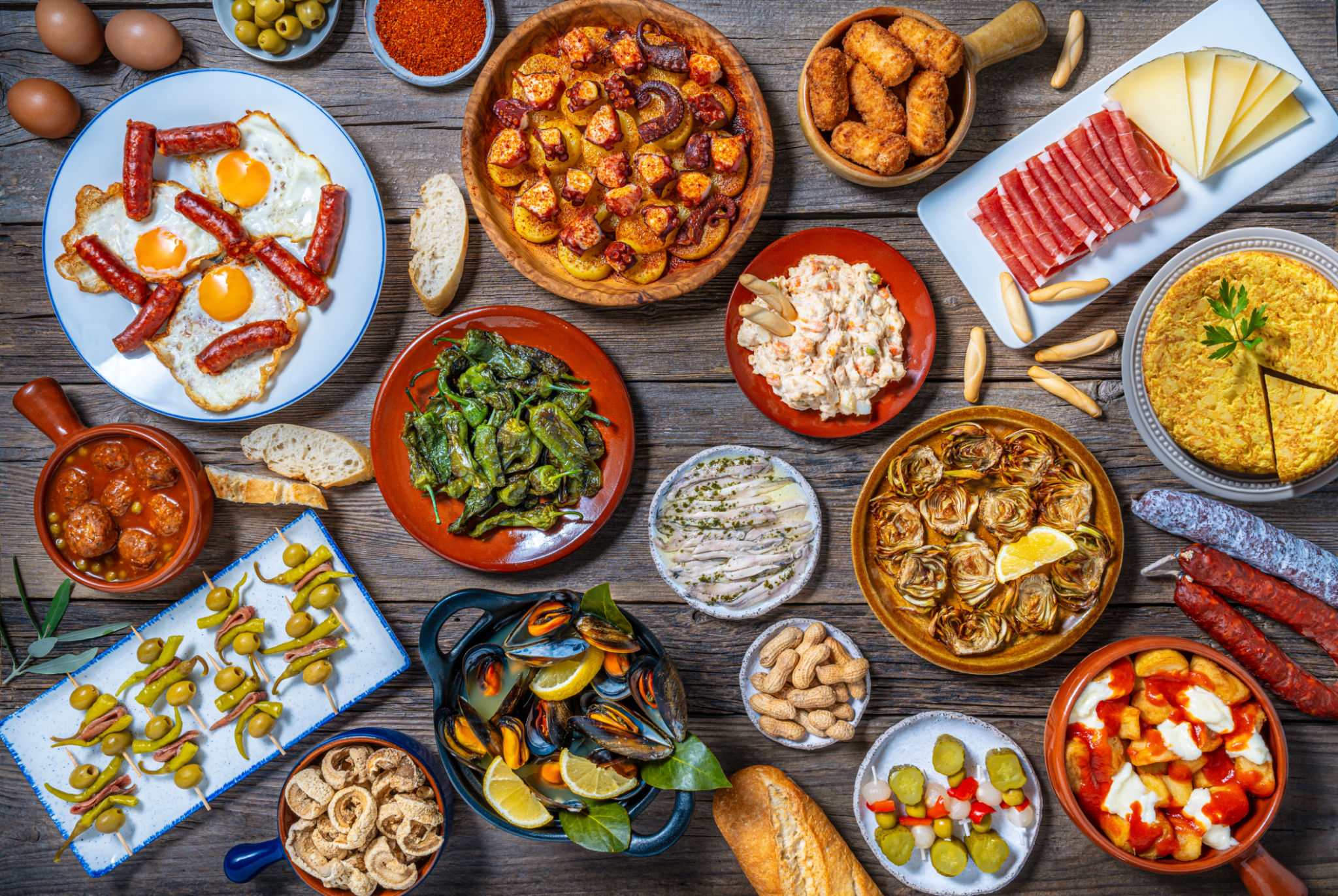 Assorted Tapas from Spain food, typical Spanish recipes, and pintxos on a rustic wood Assorted Tapas from Spain food, typical Spanish recipes, and pintxos on a rustic wood