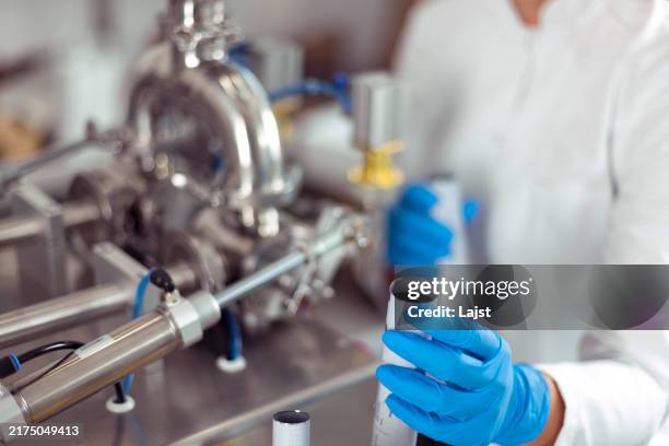 il processo di produzione di cosmetici naturali e creme per viso e capelli e il loro riempimento in confezioni - riempire foto e immagini stock