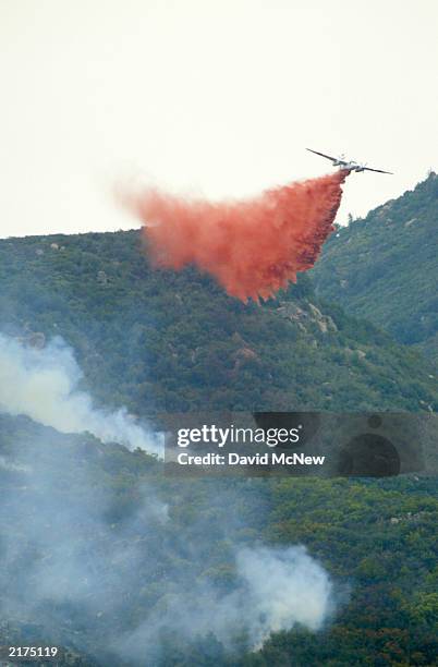 An airtanker drops fire retardant on the southwest flank as the Coyote Fire burns more than 13,000 acres of chaparral and forest on July 18 six miles...