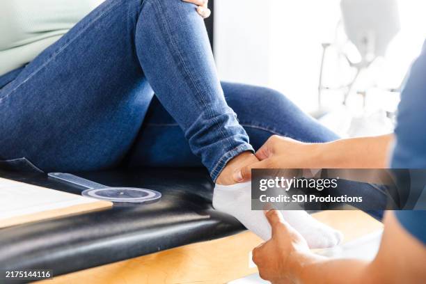 close-up unrecognizable physical therapist working with unrecognizable woman's foot - sprained ankle stock pictures, royalty-free photos & images