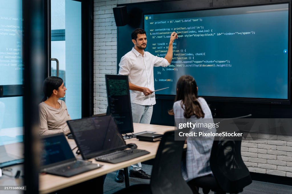Software developer team working together, discussing on coding on multi computer screen.