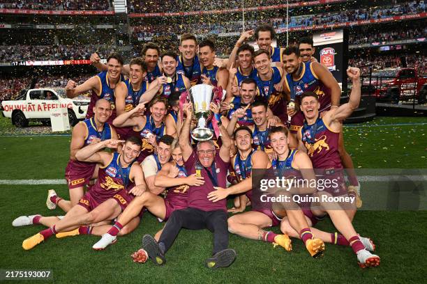 Brisbane Lions players and coach Chris Fagan, celebrate with the Premiership Cup after winning the AFL Grand Final match between Sydney Swans and...