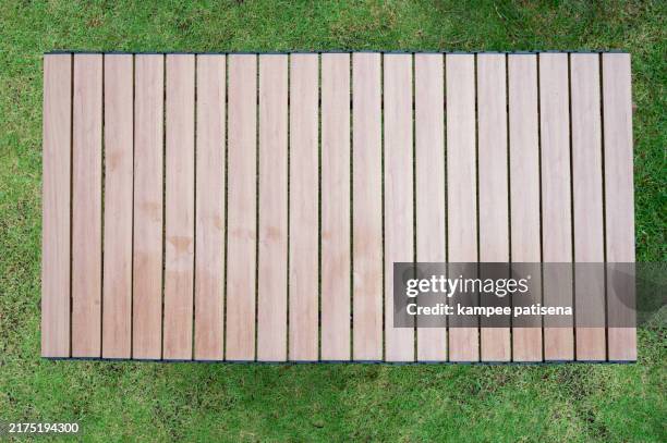 wooden table on a green lawn - table de pique nique photos et images de collection