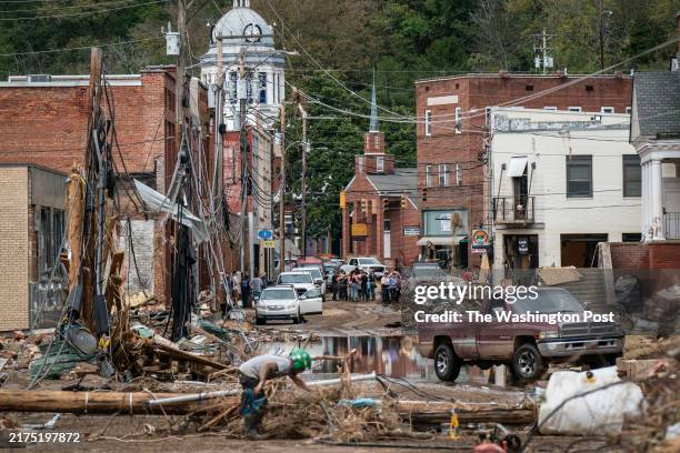 Marshall, NC Workers, community members, and business owners clean up debris in the aftermath of Hurricane Helene in Marshall, North Carolina on...