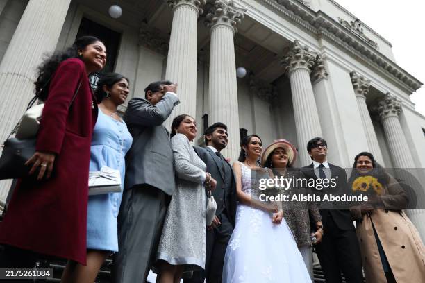 Ishan Godawatta and Ananya Bhalla pose for a picture with family outside Old Marylebone Town Hall after getting married on October 1, 2024 in London,...