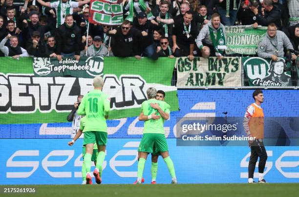 Mohammed Amoura of VfL Wolfsburg celebrates with team mate Jonas Wind after scoring his team's second goal during the Bundesliga match between VfL...