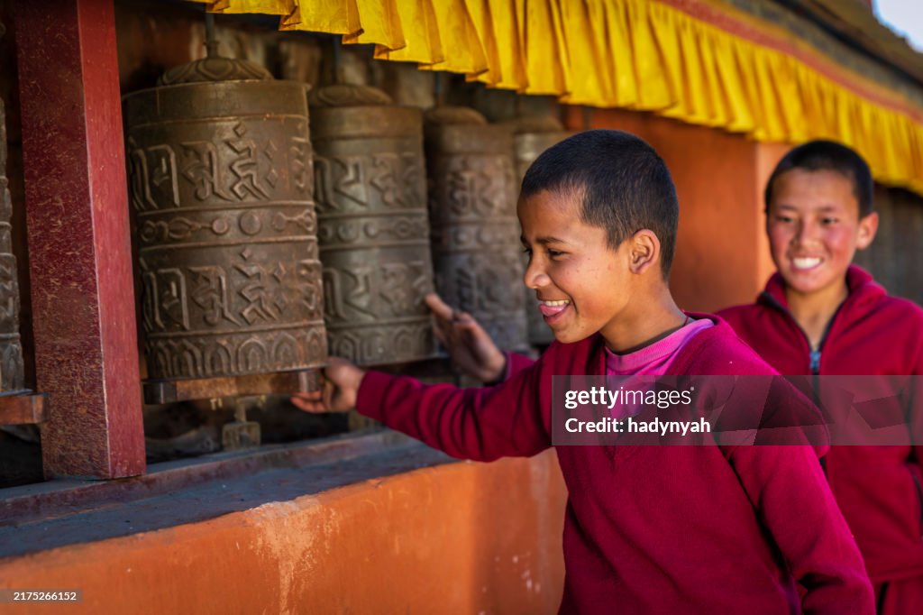 Novice Tibetan monks turning the prayer wheels, Tsarang village, Upper Mustang, Nepal