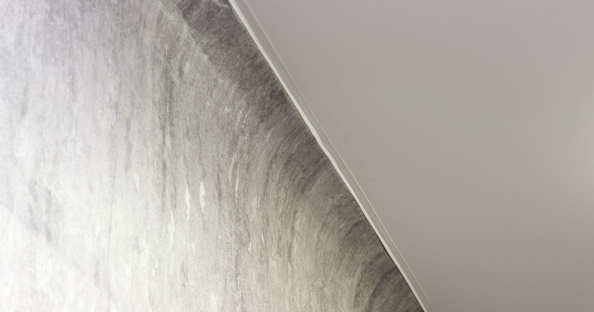 Textured wall meets ceiling at an angle, featuring modern, minimalist interior design with soft lighting. Textured wall meets ceiling at an angle, featuring modern, minimalist interior design with soft lighting.