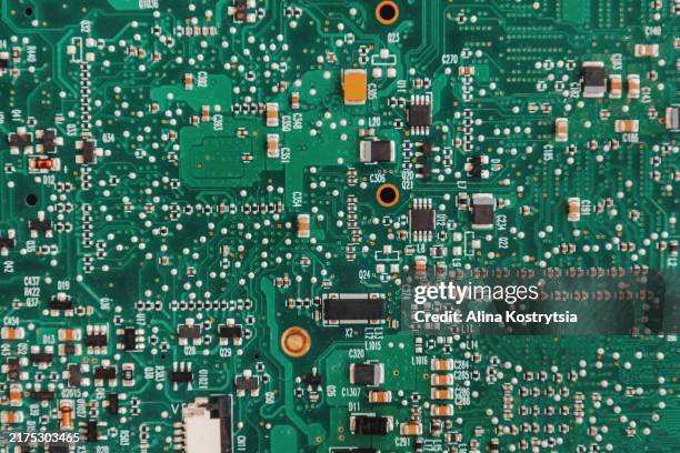 computer motherboard close-up. green background with numerous microcircuits, capacitors and resistors creates atmosphere of high technology - perspektivenwechsel stock-fotos und bilder