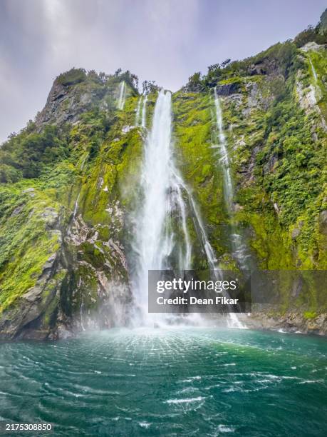 stunning waterfall in milford sound - rock face stock pictures, royalty-free photos & images