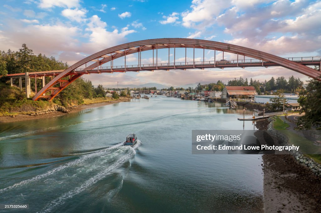Historic Rainbow Bridge in the tourist town of La Conner, Washington with a boat passing underneath.