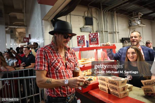 Musician Kid Rock pays for concessions as he attends the Alabama Crimson Tide versus Georgia Bulldogs college football game at Bryant-Denny Stadium...
