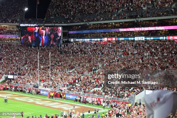 Republican presidential candidate, former U.S. President Donald Trump, waves on the big screen as he attends the Alabama Crimson Tide versus Georgia...