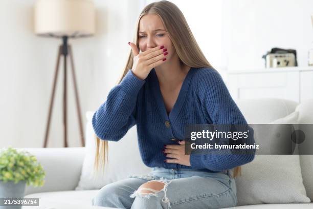 young woman closing her mouth and feeling nauseous - stroke illness stock pictures, royalty-free photos & images