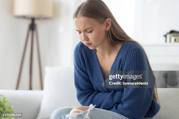 frau fasst sich vor schmerzen an den bauch - refluxkrankheit stock-fotos und bilder