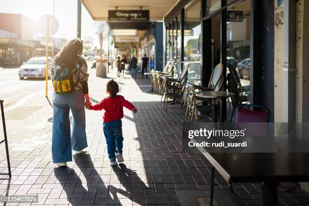an asian mother takes her son for a walk - shopping centre stock pictures, royalty-free photos & images