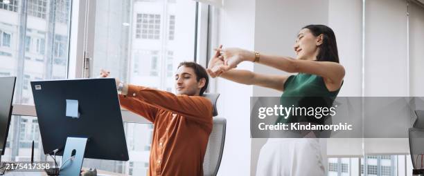 asian businesswoman and lgbtq colleague coworker at corporate workplace, stretching casual candid moment. multi-ethnic diversity business people, work life, office syndrome, healthy lifestyle concept - boa postura imagens e fotografias de stock