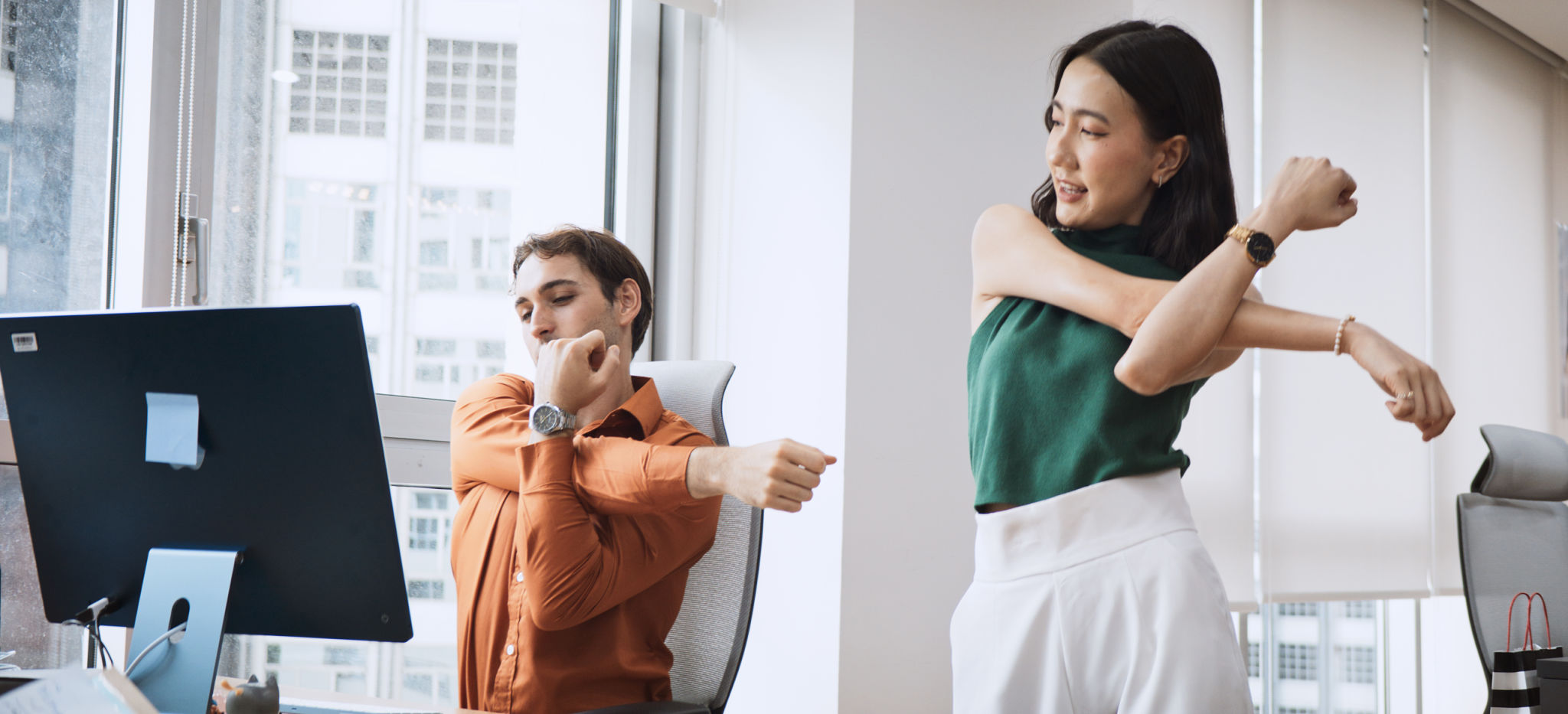 Asian businesswoman and LGBTQ colleague coworker at corporate workplace, stretching casual candid moment. Multi-ethnic diversity business people, work life, office syndrome, healthy lifestyle concept Asian businesswoman and LGBTQ colleague coworker at corporate workplace, stretching casual candid moment. Multi-ethnic diversity business people, work life, office syndrome, healthy lifestyle concept